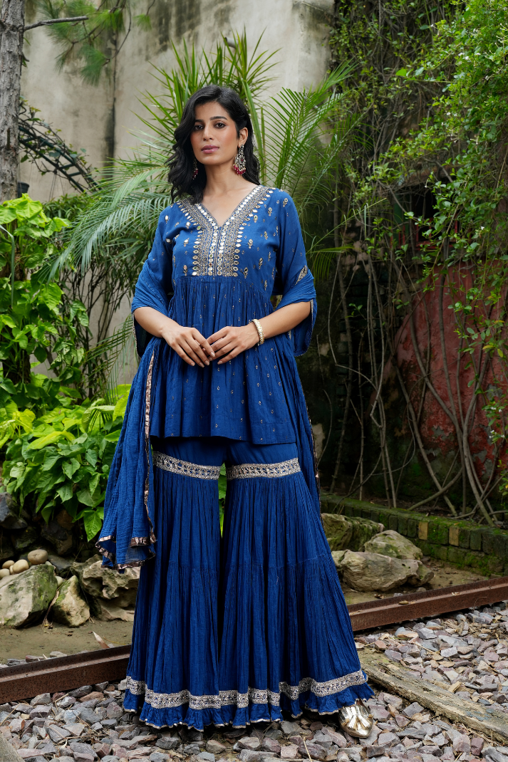 A deep blue short kurta Paired with flared sharara