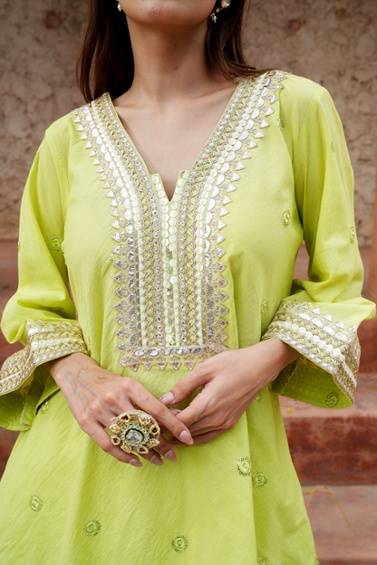 A fresh lime-green kurta with zari-woven floral motifs pants