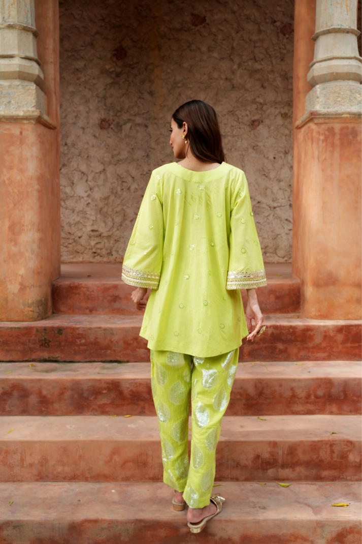 A fresh lime-green kurta with zari-woven floral motifs pants